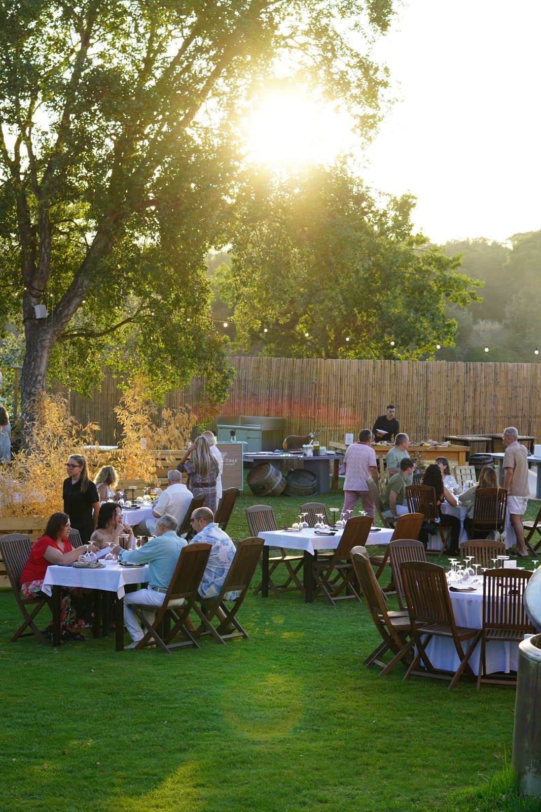 Invitados de boda al atardecer en el jardín de Can Casellas