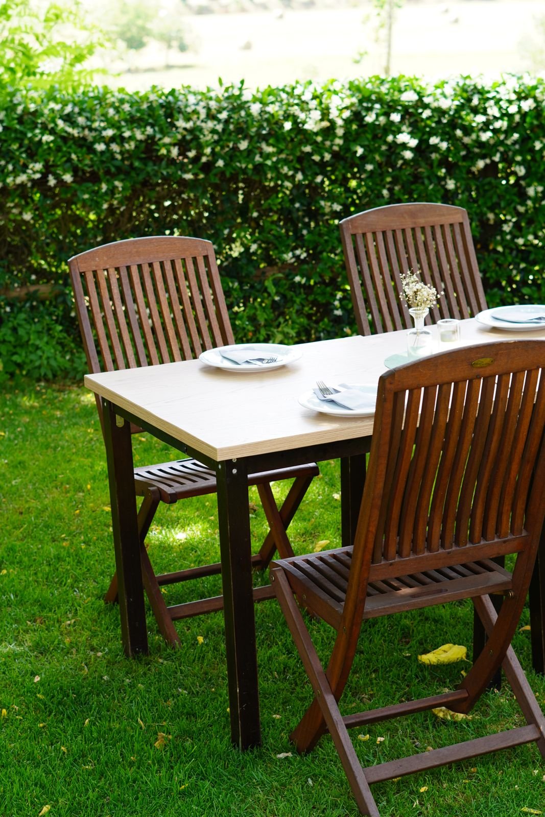 Mesa de madera en la terraza jardín de Can Casellas